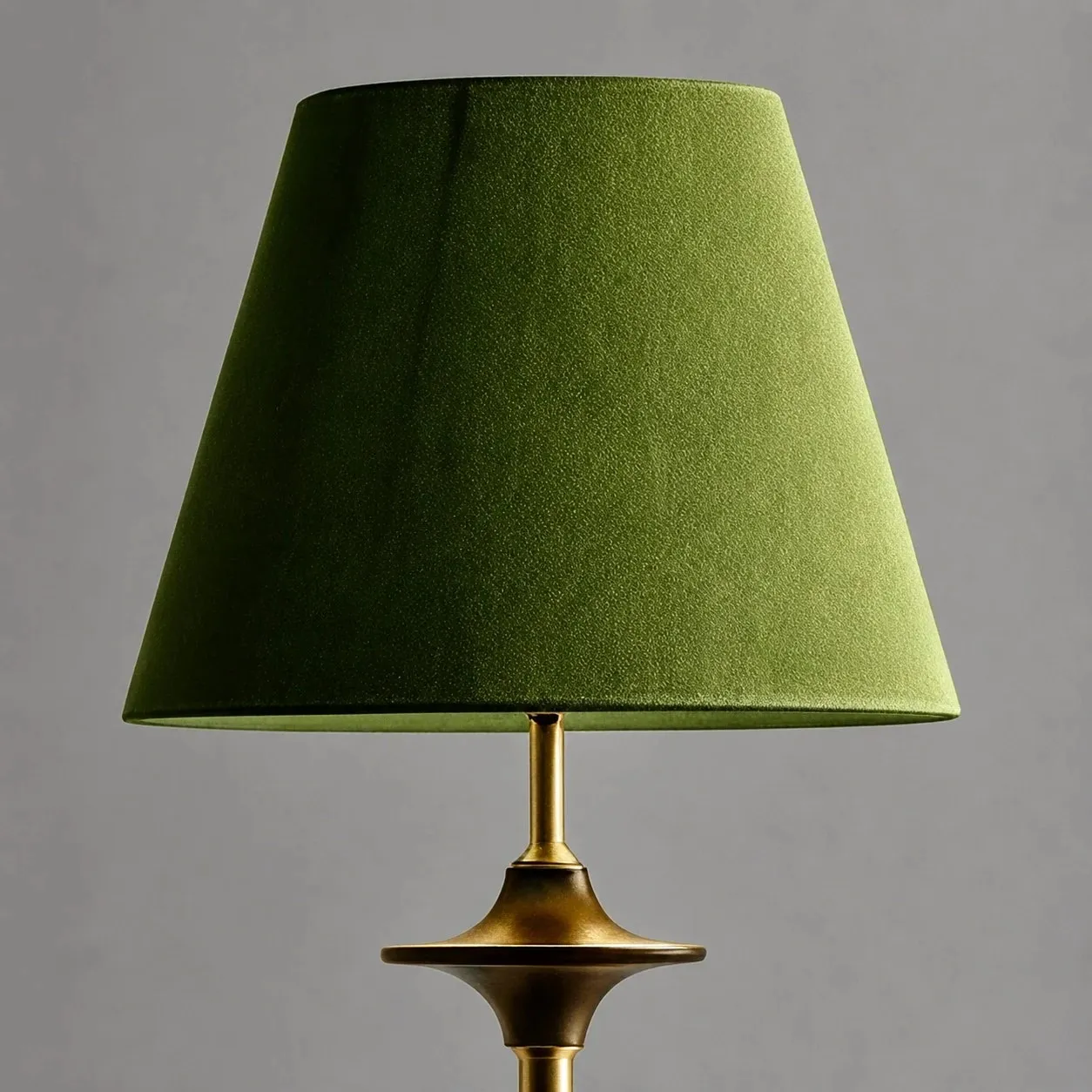 Close view of green fabric shade and brass tone stem