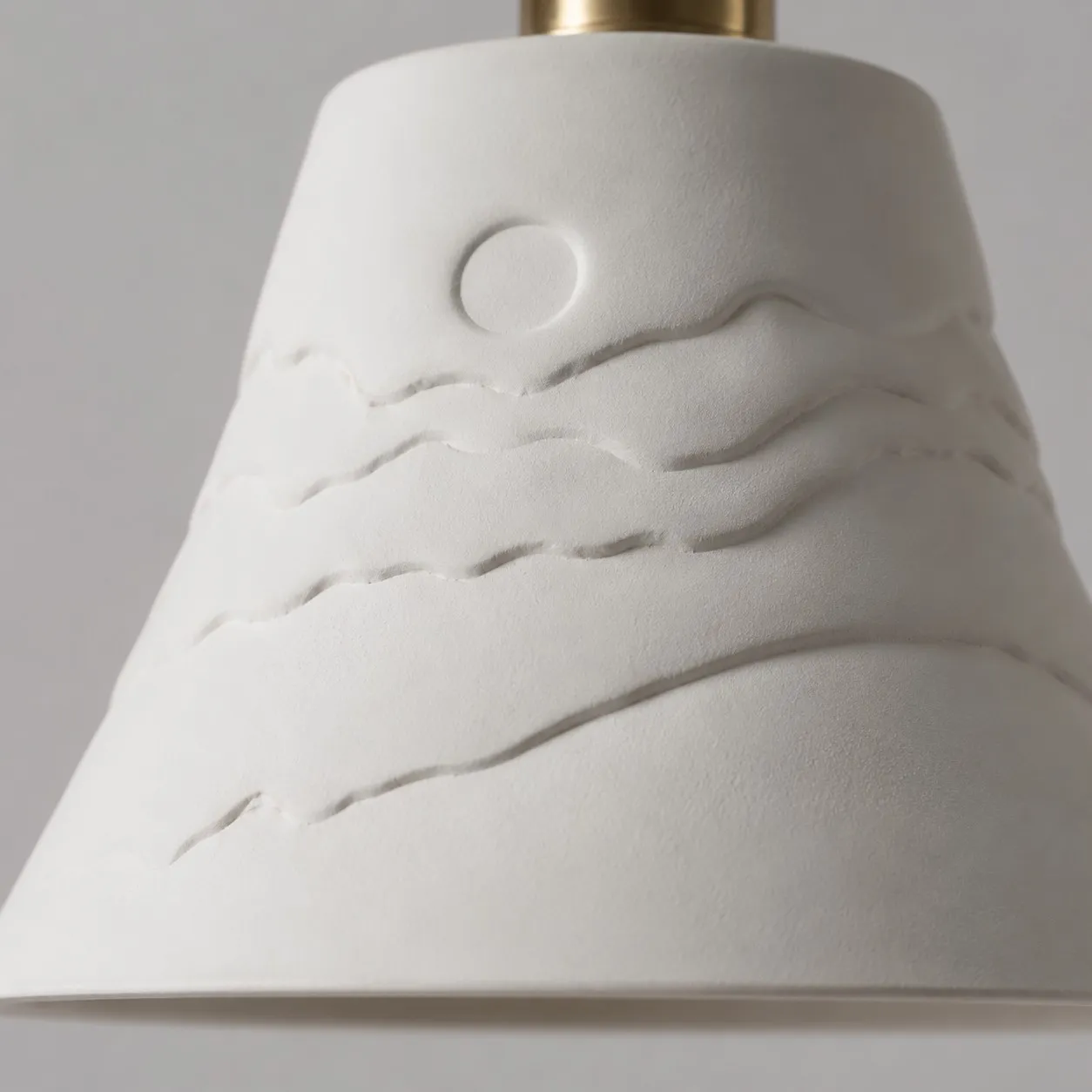 Raised sunset relief detail on the ceramic shade