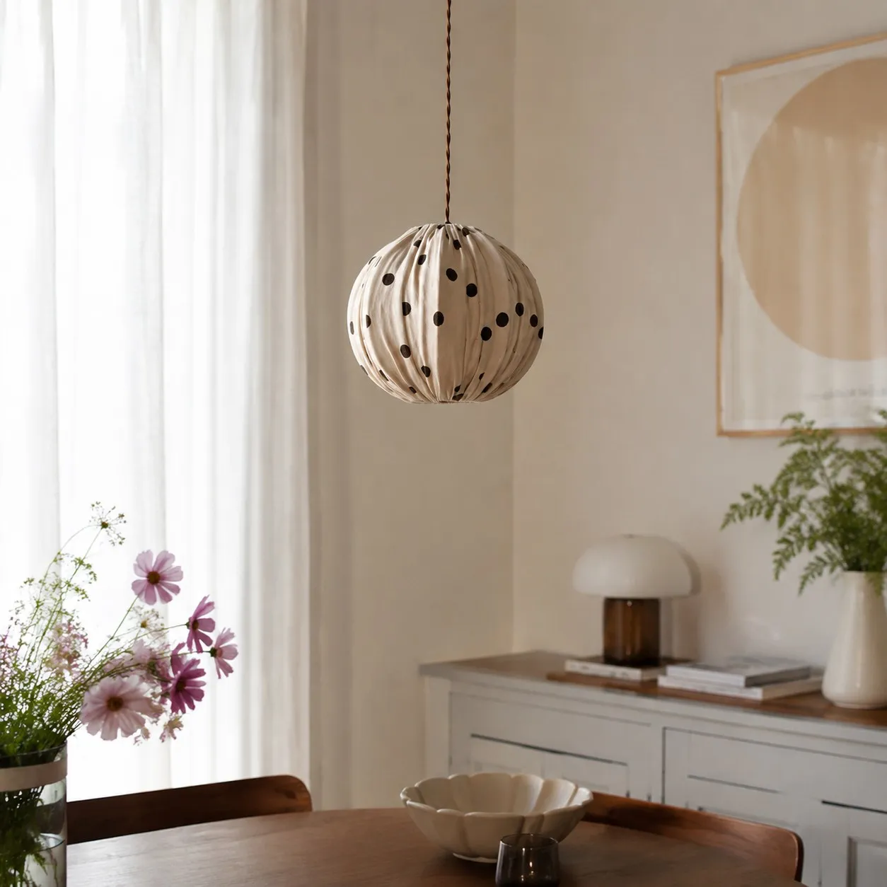 Cream polka dot pendant light near a bright window